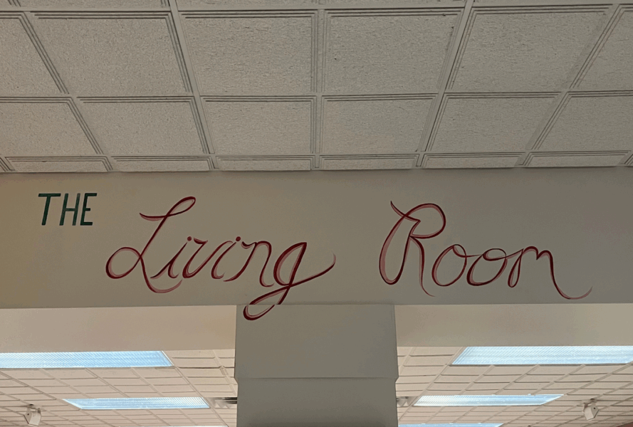 Hand painted lettering on the wall outside the downstairs living room, and spells "The Living Room."