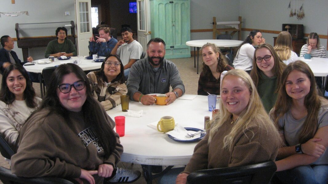 Students gather at tables to reflect after guest speakers present.