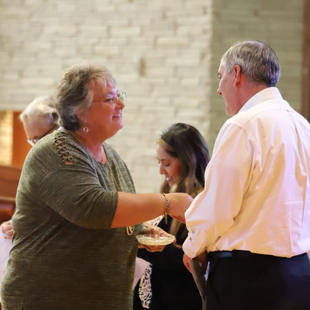 Benge (left) congratulates Beumer on receiving his pin, which marks his commitment to the ASC Associates program.