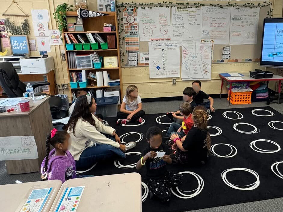 Pictures Puentes Probedo sat on the classroom floor with children sat around her