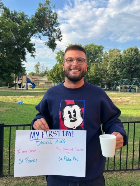 Mies holds up a "My first day" sign as he begins his fall semester at Newman.