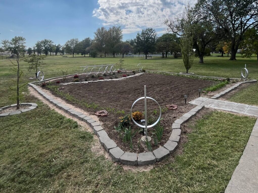 Pictures the Martyr's Garden with cylinders on each corner and the five cylinders lined up in the back center