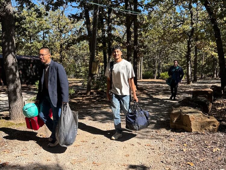 Students carry their belongings to their temporary retreat home.