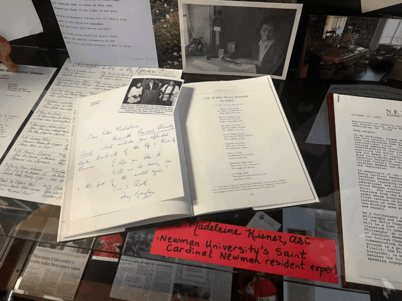 Shows Sister Madeleine Kisner's poem displayed in an open book in the display case