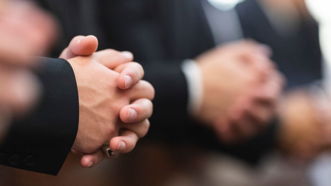 Hands folded in prayer in St. John's Chapel