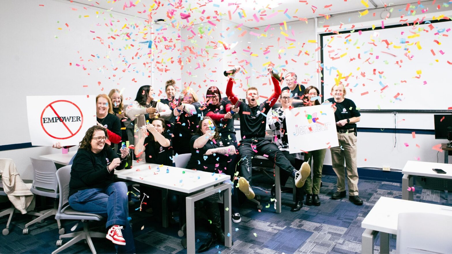 Confetti fills the air as staff and faculty of the J1 implementation team celebrate the launch of a new student information system at Newman University.