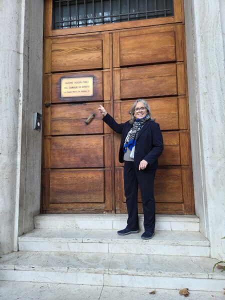 Jagger points to a plaque on the front door of the residence of Rome's ASC sisters.