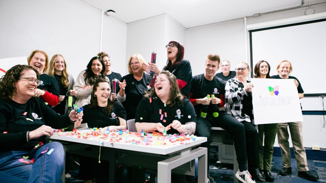 The J1 implementation team cheers on the launch day of Newman's new student information system.