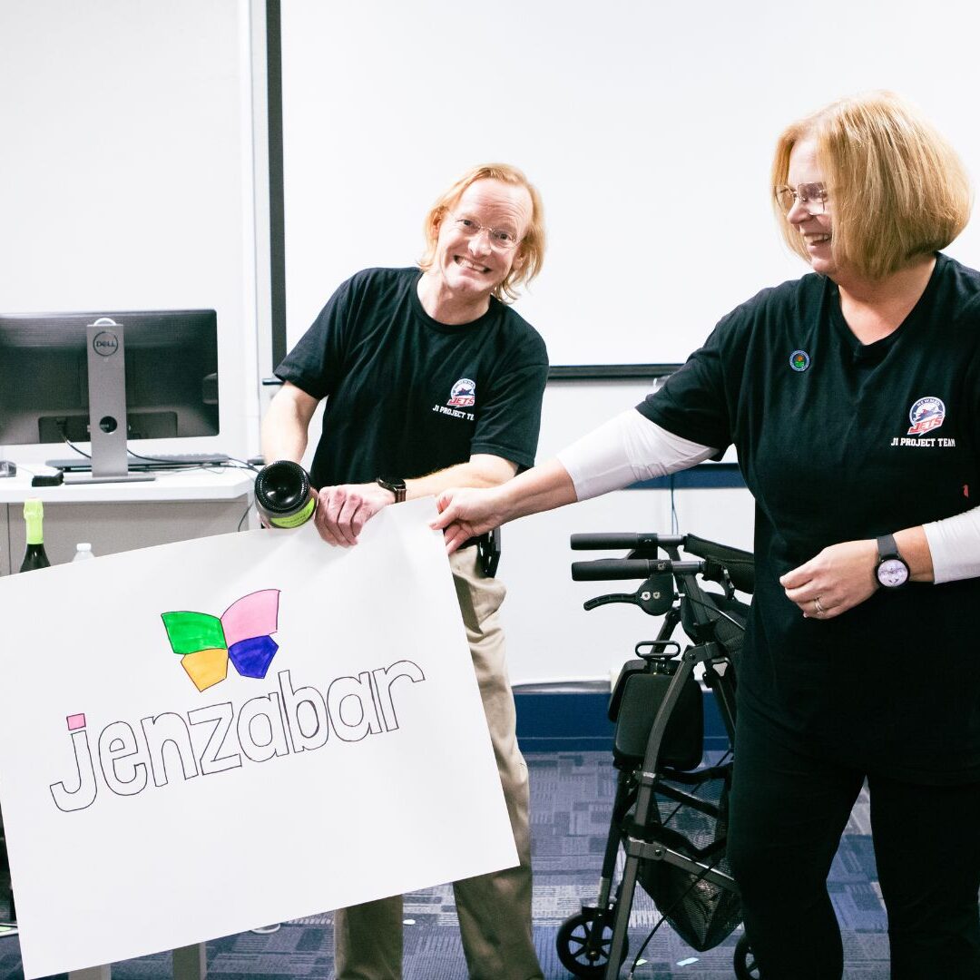 Vaughan (left) holds up a "Jenzabar" sign.