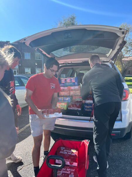 Students and staff unload a car filled with items to restock the Jets Resource Hub (Courtesy photo: Natalia Lopez).