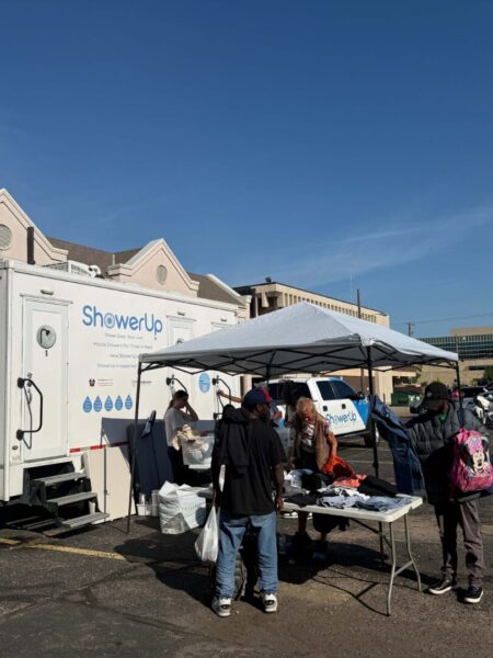 Shows ShowerUp booth set up at the clinic with people coming up to it