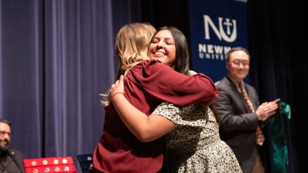 A graduate hugs Director of the Respiratory Care Program Stacie Fox during the School of Healthcare Professions pinning ceremony.
