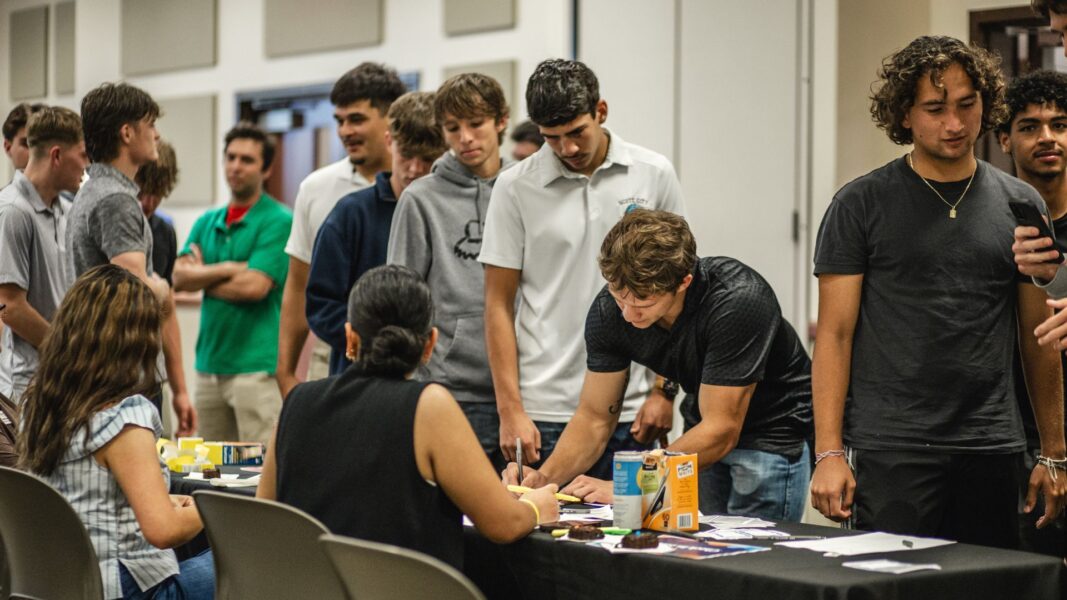 Students check in at a table during a School of Business & Technology mixer.