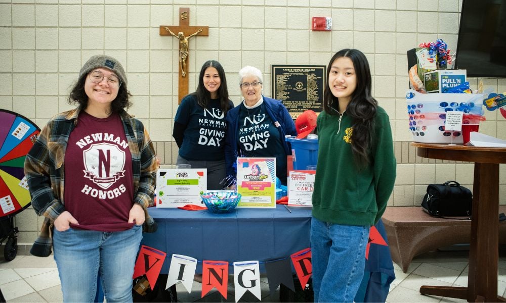 Students, staff and an ASC sister celebrate Giving Day with a booth in Eck Hall.