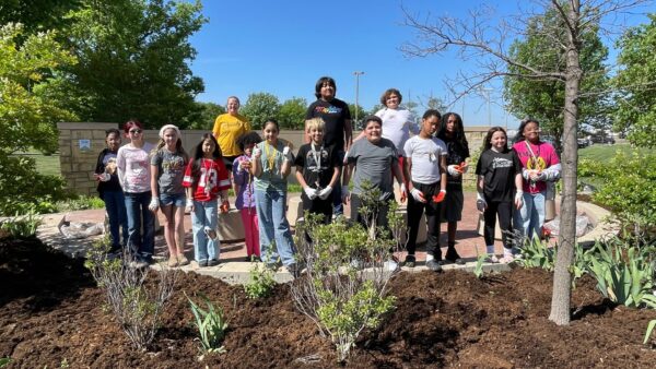 The student visitors smile near the Heimerman Plaza at Newman, where their Earth Week service project took place.