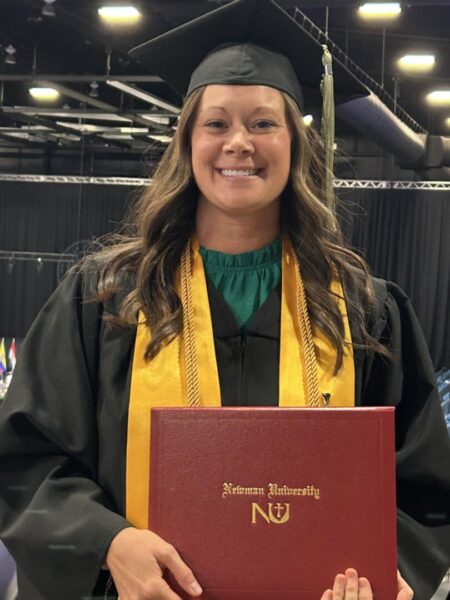 Smith smiles with her graduation cap, gown and stole at Newman's May 2025 commencement ceremony.