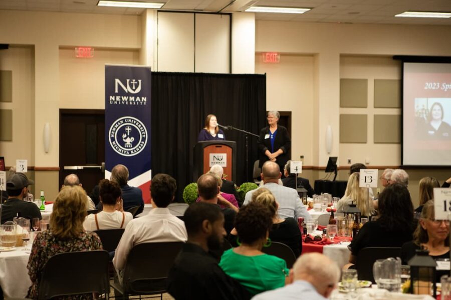 Former National Alumni Board President Miles (right) introduces an alumni award winner during the Newman Legacy Banquet.