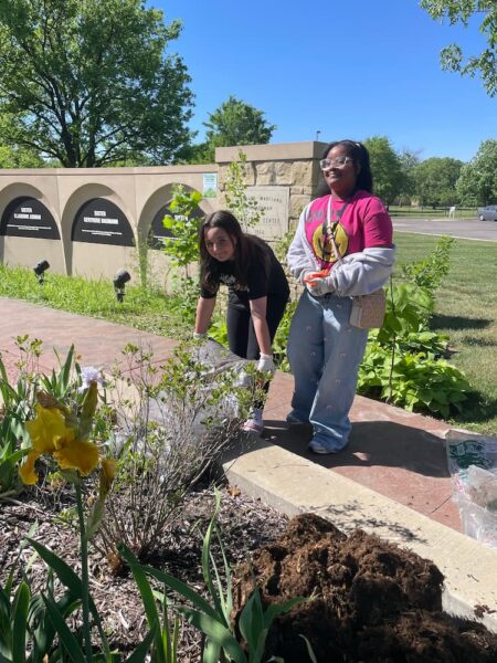 Two Mayberry middle schoolers empty mulch into the flowerbeds at the Heimerman Plaza on campus.