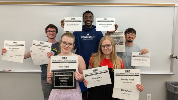 The Vantage staff holds up awards won at the Kansas Collegiate Media Conference.