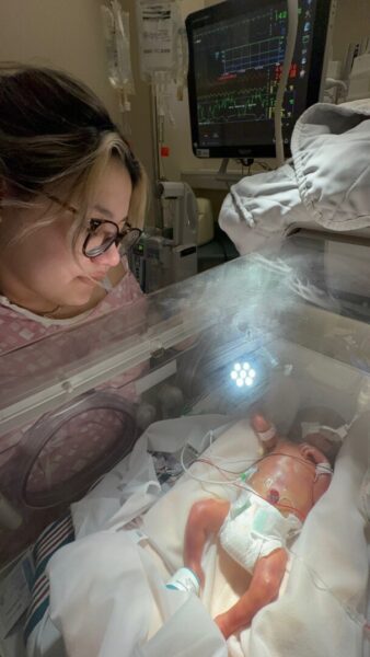 Flores-Lerma looks lovingly upon her son in the NICU.