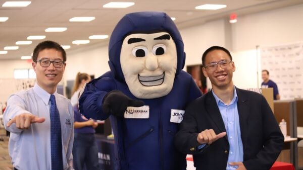 Johnny Jet poses with a professor and student during Accepted Students Day.