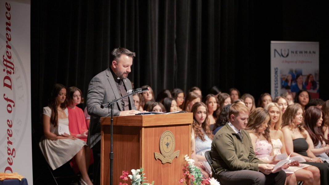Herzog prays over the graduates, calling on God, "our divine healer."
