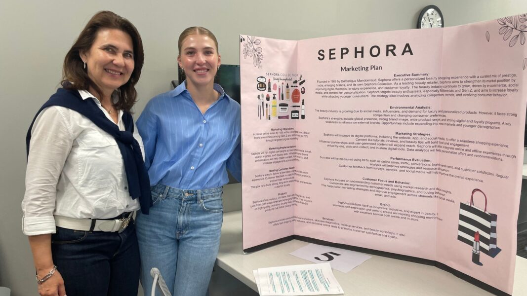 Bono and her mother stand next to her Scholars Day poster.