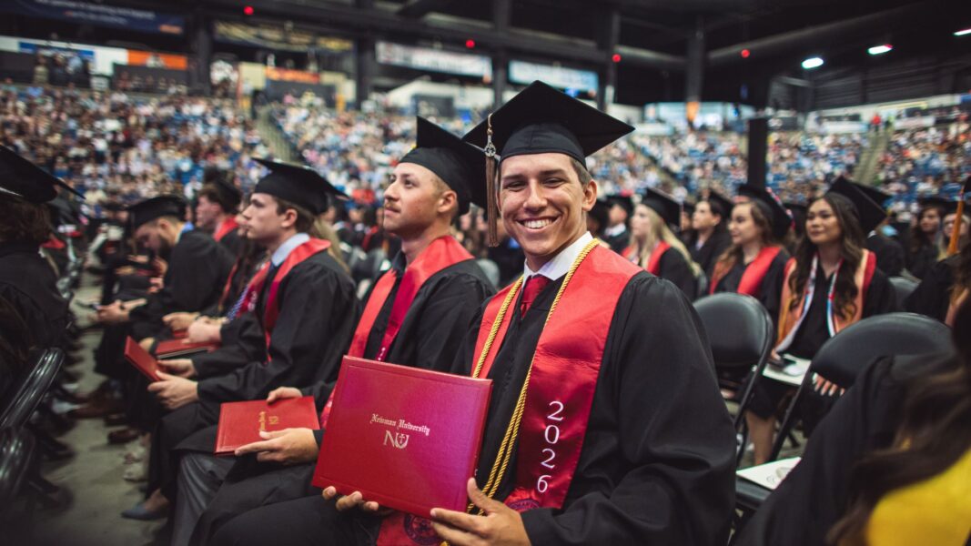 Munn smiles with his Newman diploma at graduation.