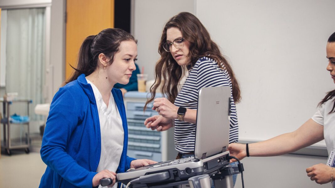 A student charts information on the patient using medical technology.