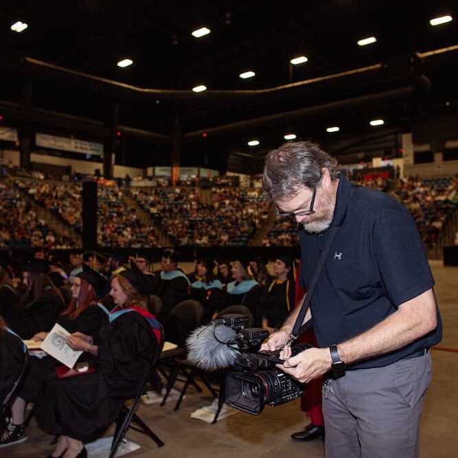 Sanny in action with the video camera at Newman's commencement ceremony on May 16.