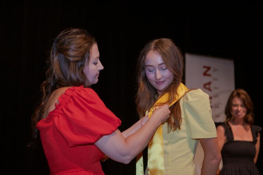 Graduates receive their ceremonial pins.