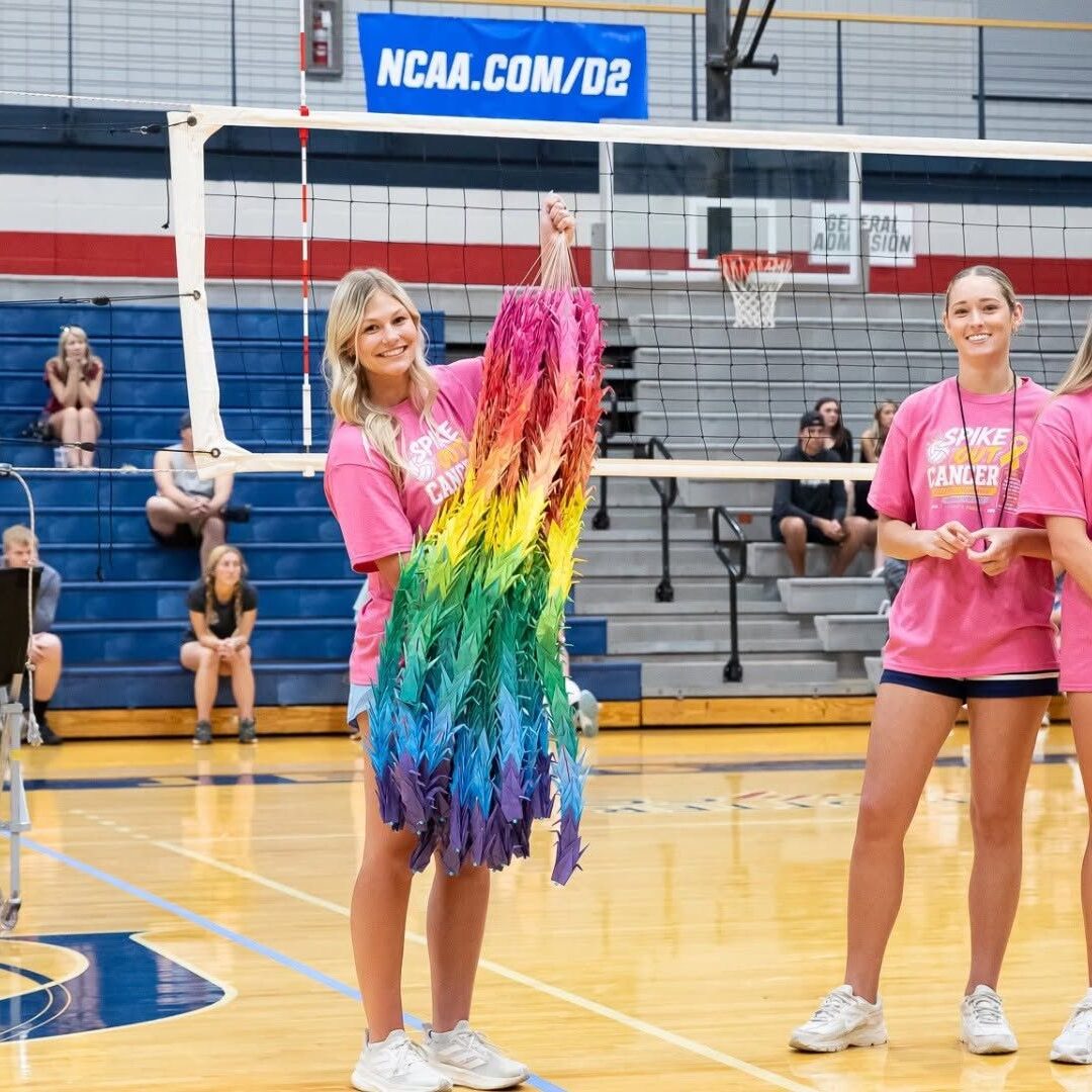 Lane holds a Senbazuru, a collection of origami cranes made by the Asian Student Association, during the Spike Out Cancer Volleyball Tournament.