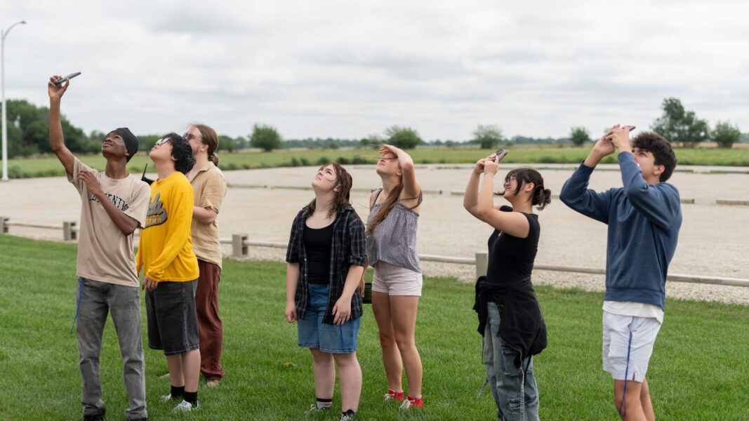 Students look to the sky as the agricultural drone takes flight.