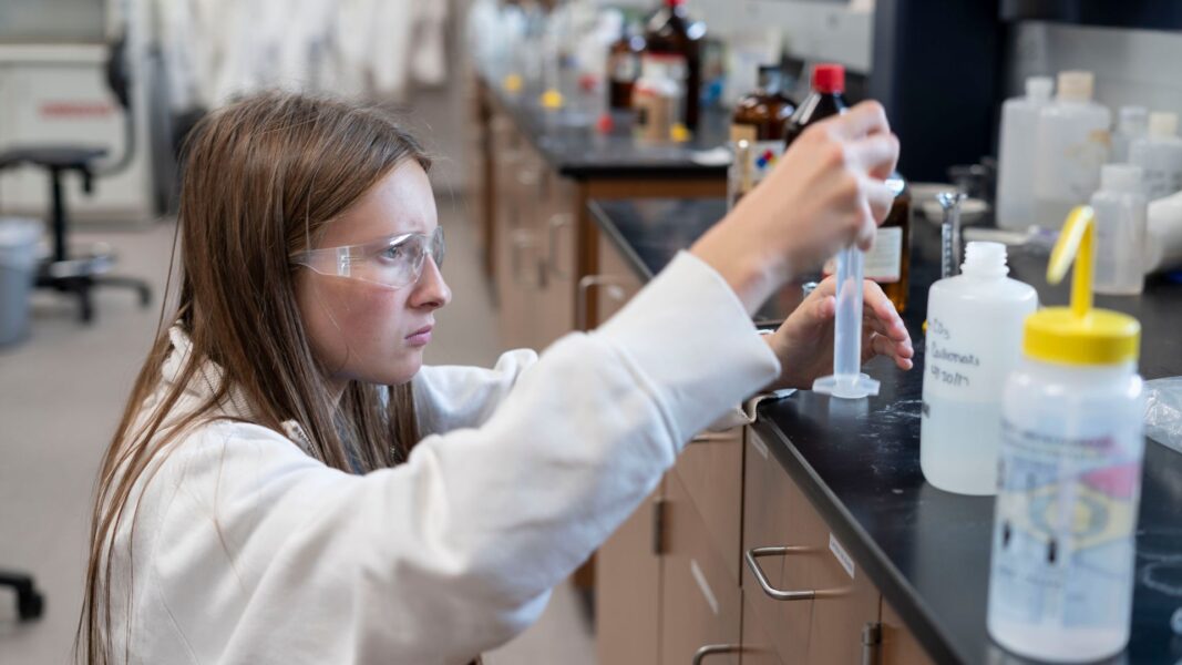 A student carefully handles a chemical solution during ISSP.