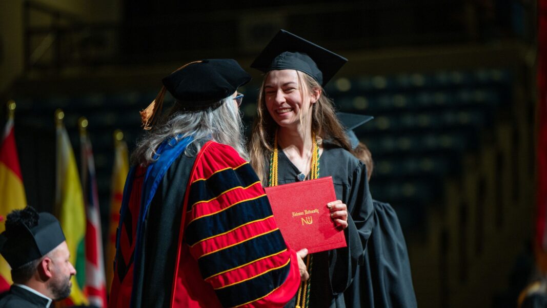 Strickbine accepts her degree on stage during Newman's spring commencement ceremony.