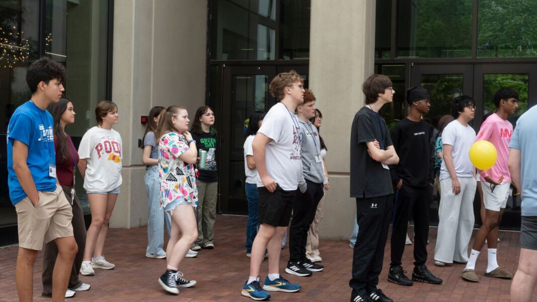 ISSP campers watch as Professor Huschka conducts an outdoor experiment.
