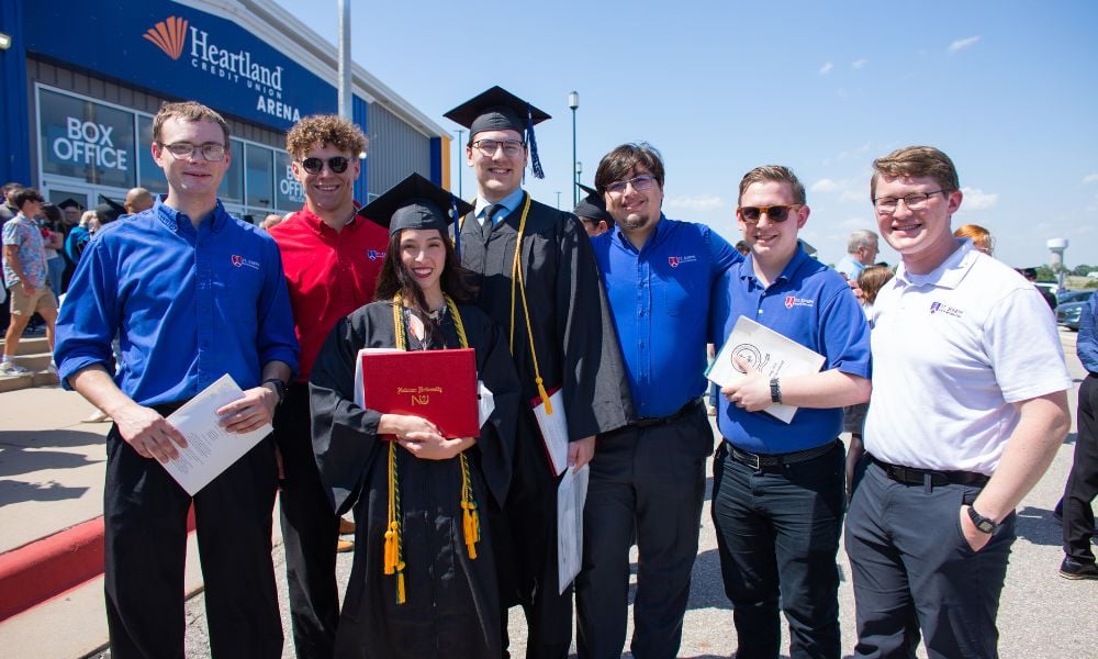 Caleb Papsdorf (center, left) with friends after the 2026 Newman commencement ceremony.