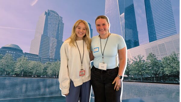 (From left to right) Crumley and Edwards in front of a photo from Lower Manhattan, New York.