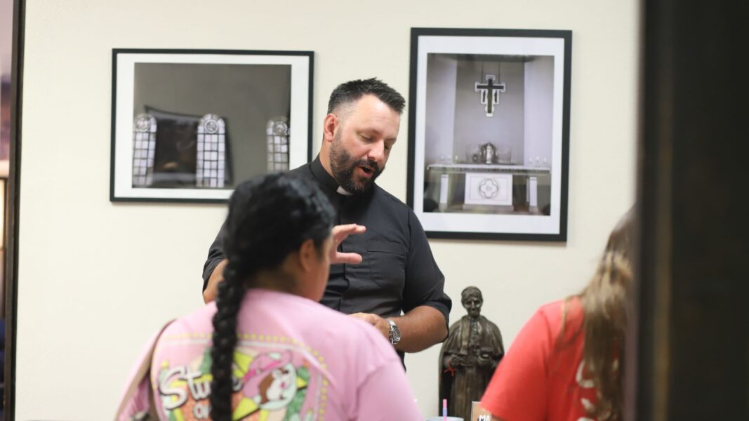 Fernandez and her mom chat with Newman Chaplain Father Ed Herzog in the Campus Ministry office.